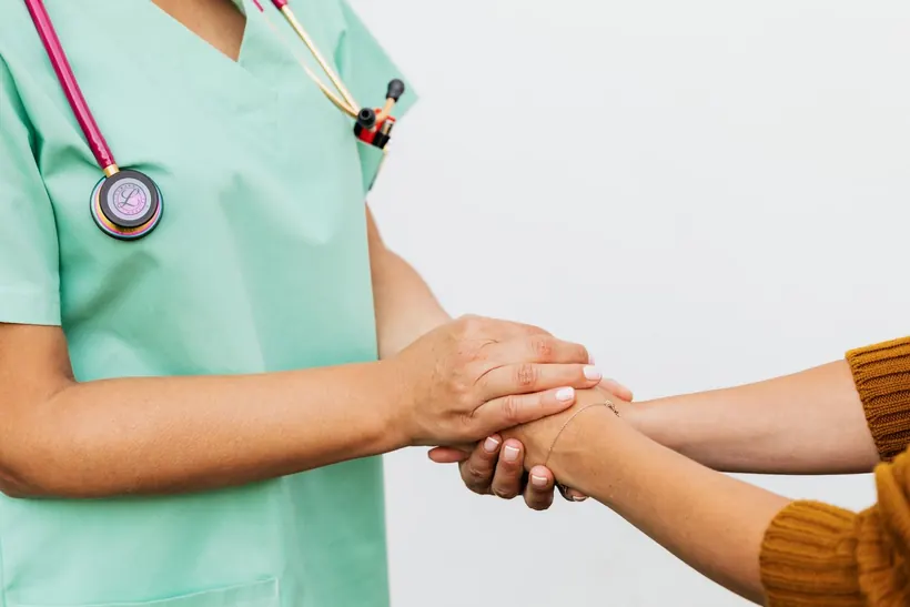 A doctor holding a patient's hand